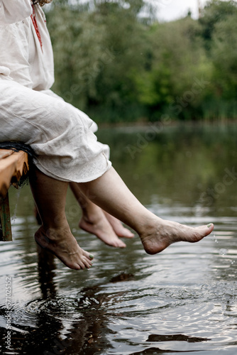 female feet splashing in river water