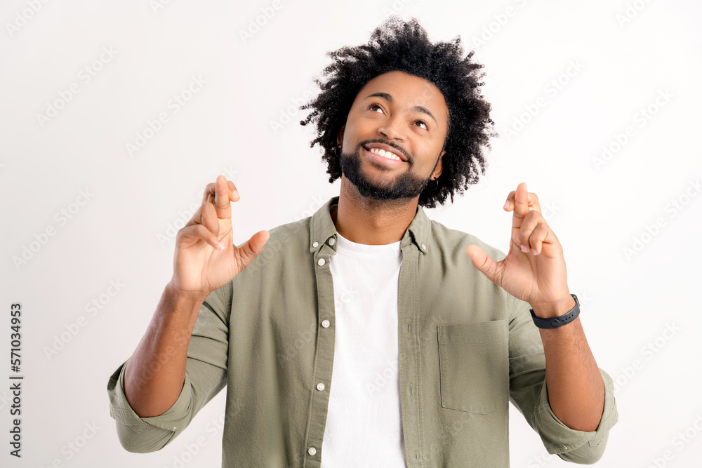 Attractive curly handsome young guy holding fingers crossed isolated on white, charismatic african-american man wishing something, making good luck sign, dreaming, desire Attractive curly handsome young guy holding fingers crossed isolated on white, charismatic african-american man wishing something, making good luck sign, dreaming, desire
