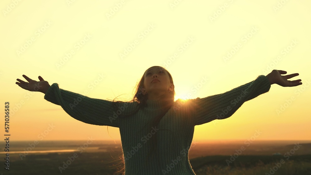 young girl prays looking up sky with her hands up. offer forgiveness, help, confession. man dream.religious girl at sunset. women faith. travel millennial outdoors. girl hair wind rays sun. love life.