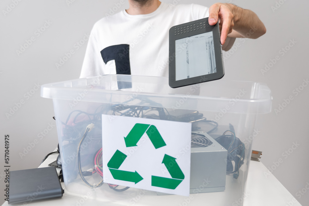 Man throwing away broken electronic book in recycle container