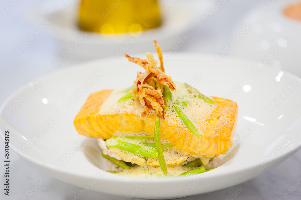 Close-up of salmon fillet with rice cakes, green beans, lemon butter garlic sauce. Seafood dish on white plate. Healthy lunch on cafe table. Food, recipe, restaurant menu background. Pescatarian diet. Close-up of salmon fillet with rice cakes, green beans, lemon butter garlic sauce. Seafood dish on white plate. Healthy lunch on cafe table. Food, recipe, restaurant menu background. Pescatarian diet.