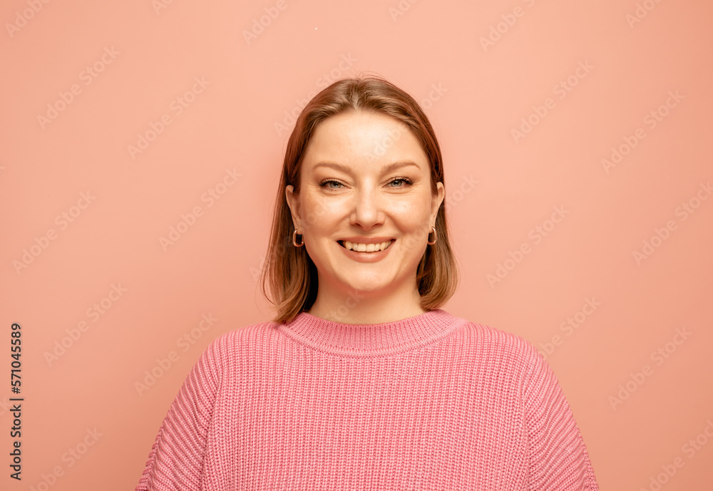 Portrait of cheerful pretty woman wearing pink sweater over pink background Portrait of cheerful pretty woman wearing pink sweater over pink background