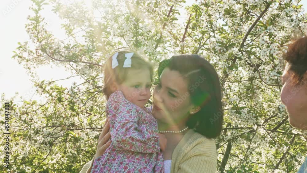 happy mother and daughter on a walk with family and friends in a spring park happy mother and daughter on a walk with family and friends in a spring park