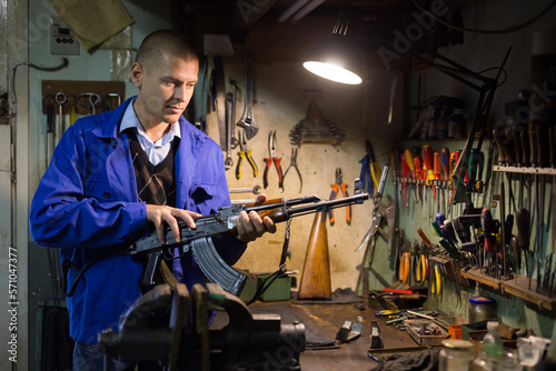 Gunsmith checks Kalashnikov assault rifle in a weapons workshop
