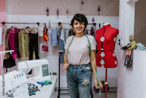 young hispanic woman fashion designer stylish working with mannequins standing and colorful fabrics at fashion studio in Mexico Latin America