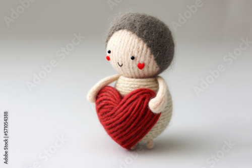 cute crochet doll holding a red yarn heart, generative AI © Luizella