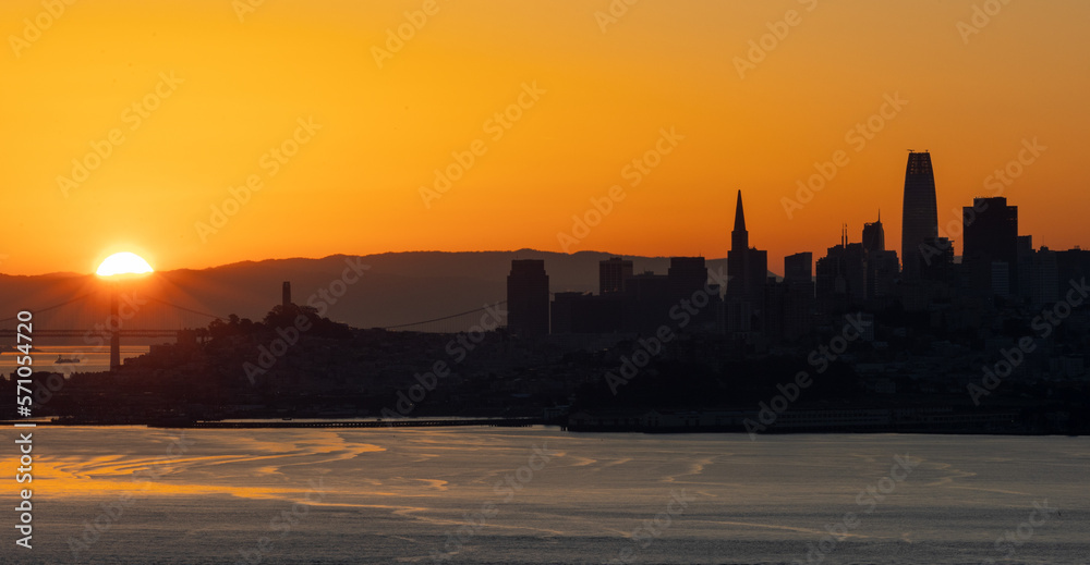 Sunrise just breaking over the horizon with the San Francisco skyline in the foreground