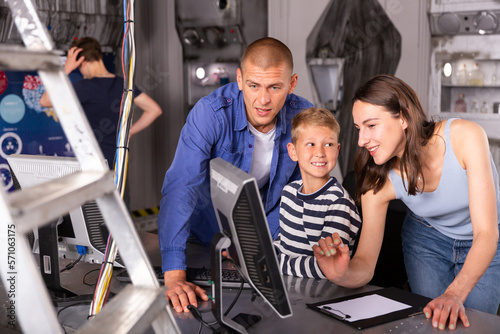 Portrait of a friendly family at a computer, thinking about solving a puzzle in a quest room, stylized as a laboratory