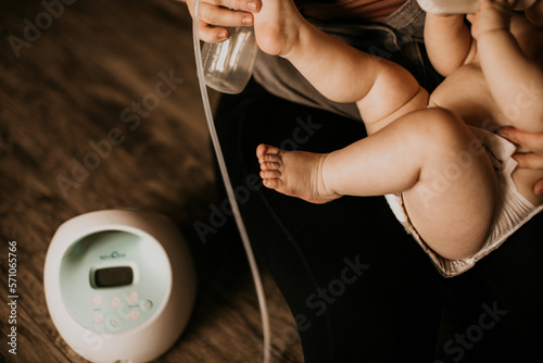 mom pumping breastmilk with toddler