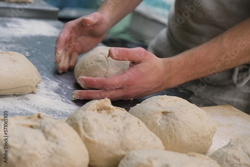 Fototapeta Naklejka Na Ścianę i Meble -  baker at work. The baker shapes the bread. Hands on the close-up form bread