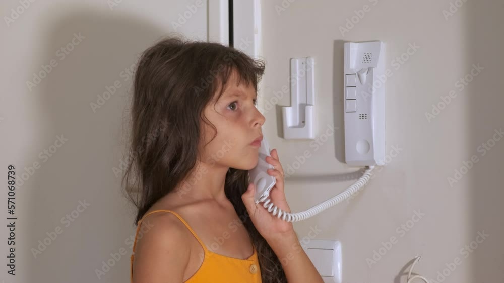 Allowing entry with intercom. A nice little girl allow to enter in the flat with smart intercom. A concept of safety children life. Allowing entry with intercom. A nice little girl allow to enter in the flat with smart intercom. A concept of safety children life.
