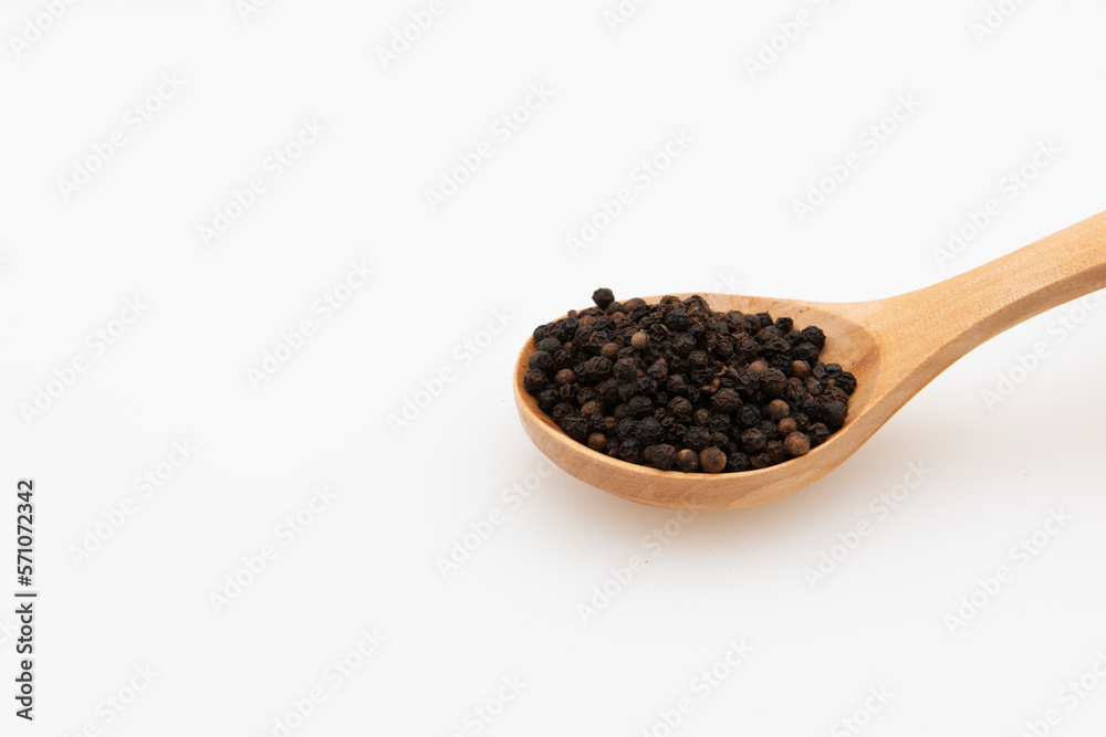 Cuchara de madera con granos de pimienta negra, aislado en blanco Cuchara de madera con granos de pimienta negra, aislado en blanco