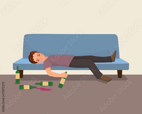 Drunk young man lying on sofa with alcohol bottles on the floor
