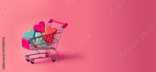 supermarket trolley or basket with hearts on magenta background. Shopping, sale, discount Space for text