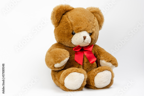 Cute Brown Teddy bear with a red ribbon on a white background. Plush toys for kids. © Stefan