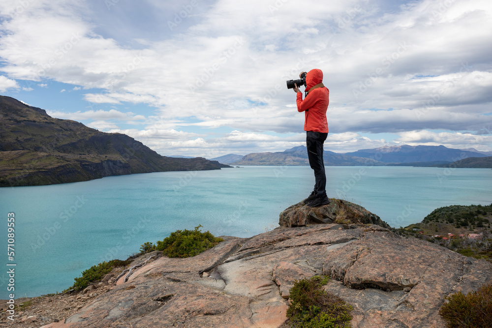 person in red jacket on top of a hill taking photo of the landscape, nature photographer, Patagonia, Chile