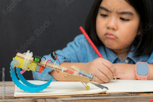 Setting right. Enthusiastic elementary school pupil fixing the robot made of cconstruction set at science lesson. photo