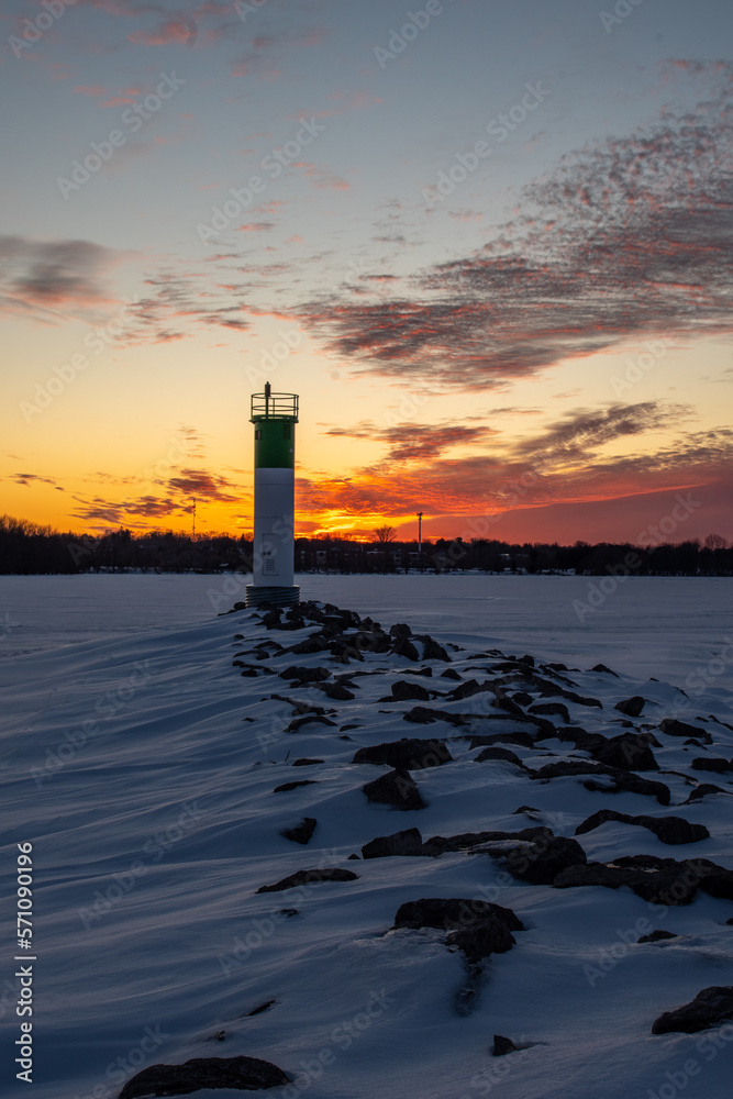 Fototapeta premium Lighthouse in frozen lake at sunset, Ontario, Canada