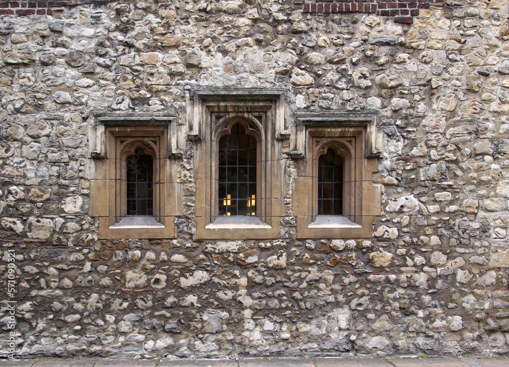 Ancient worn down stone facade around some windows of the Westminster School in London, dating from the middle ages