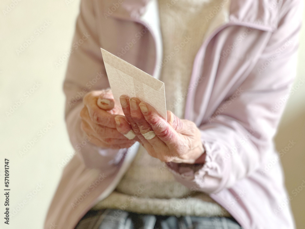 封筒を持つ高齢女性の手