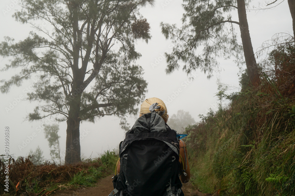 A blonde woman hiking at mount Ijen in Banyuwangi, East Java, Indonesia.