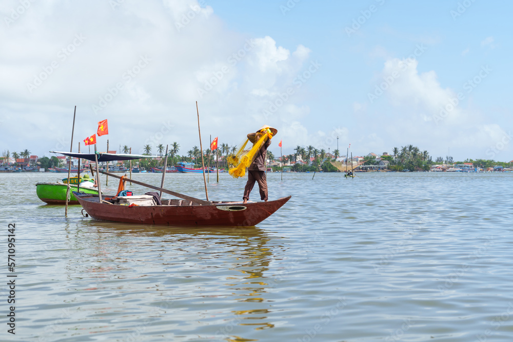 Fisherman Fishing Net on the boat at Cam thanh village. Landmark and popular for tourists attractions in Hoi An. Vietnam and Southeast Asia travel concepts