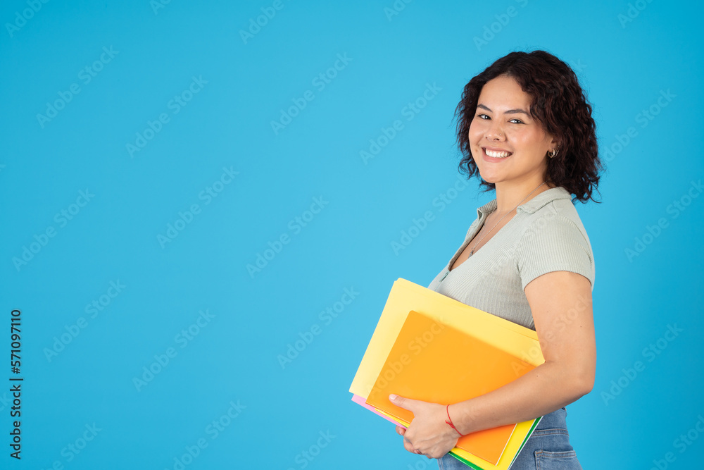 Young female student smiling with her colorful folders and notebooks Young female student smiling with her colorful folders and notebooks