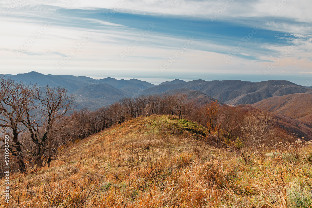 Mountain landscape with beautiful Caucasian nature. The slope of the mountain with dry grass. View from a great height in a picturesque place of the Caucasus. Caucasian mountain landscape with steep r