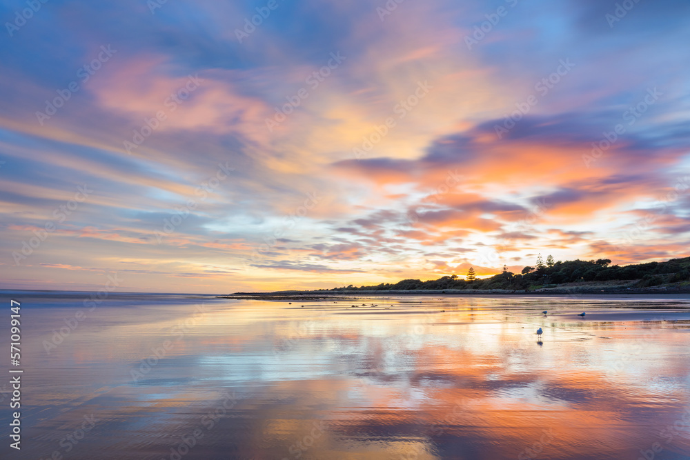 Long exposure sunrise with purple, pink, and blue at the beach in Fitzroy, New Plymouth, New Zealand