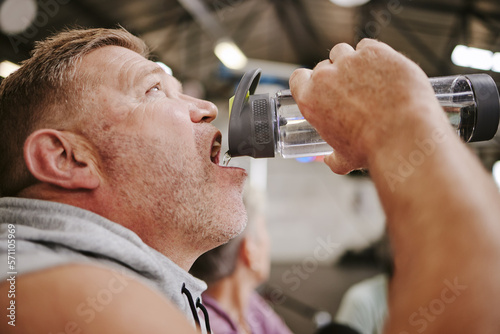 Exercise, man and drinking water in gym, wellness and after training for goal, workout and fitness. Male, athlete and bottle for aqua, liquid and energy for practice, cardio and power with hydration