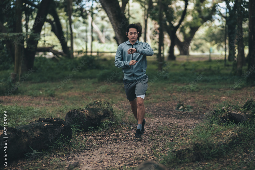 sport man checking at smartwatch during training and running in the park. Outdoor workout, Healthy lifestyle concept. sport man checking at smartwatch during training and running in the park. Outdoor workout, Healthy lifestyle concept.