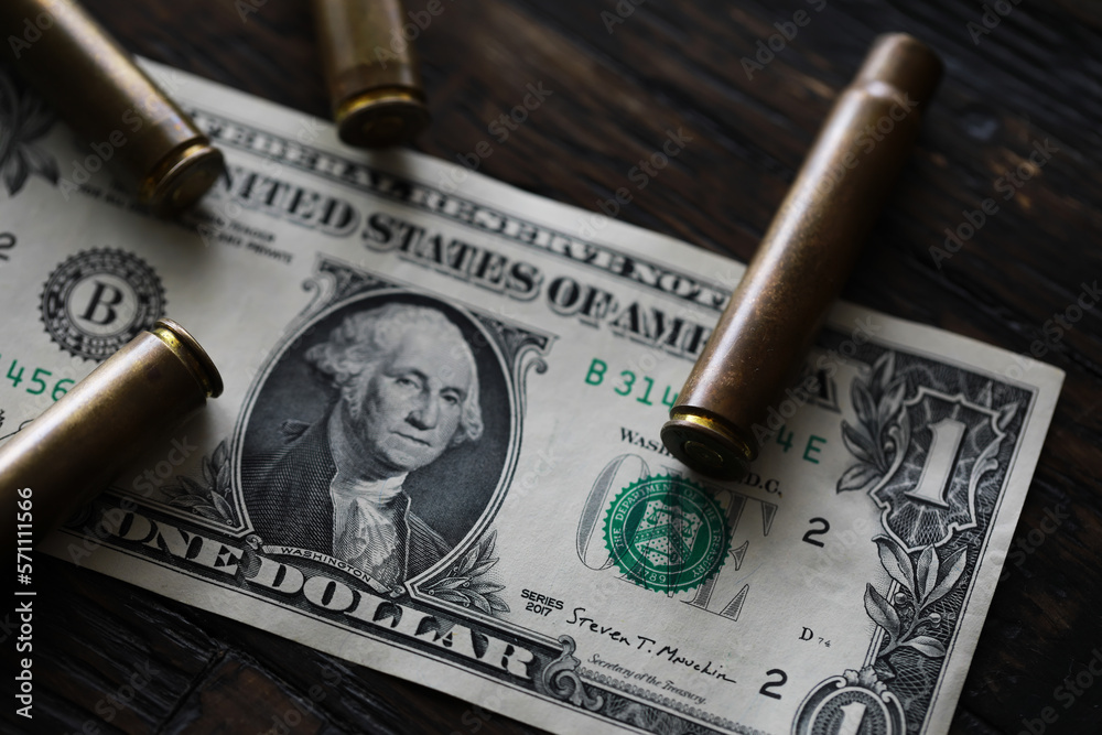 Illegal selling, criminal money concept, US dollars and bullet for a gun, cartridges on a background
