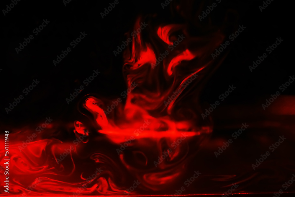 Red smoke over black studio background. Red steam on a black background. Copy space. Red smoke over black studio background. Red steam on a black background. Copy space.