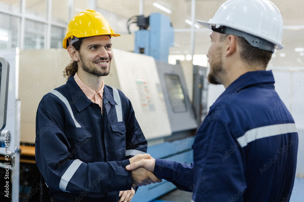 male engineers smiling wear helmets safety shake hands partner success at factory workshop. professional technician agreement plan production factory. male engineers smiling wear helmets safety shake hands partner success at factory workshop. professional technician agreement plan production factory.