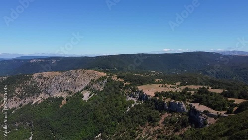 Drone image of a mountainous landscape. The green of the trees and the gray of the rocks contrast with the blue sky. Urbasa Andia mountain range photo