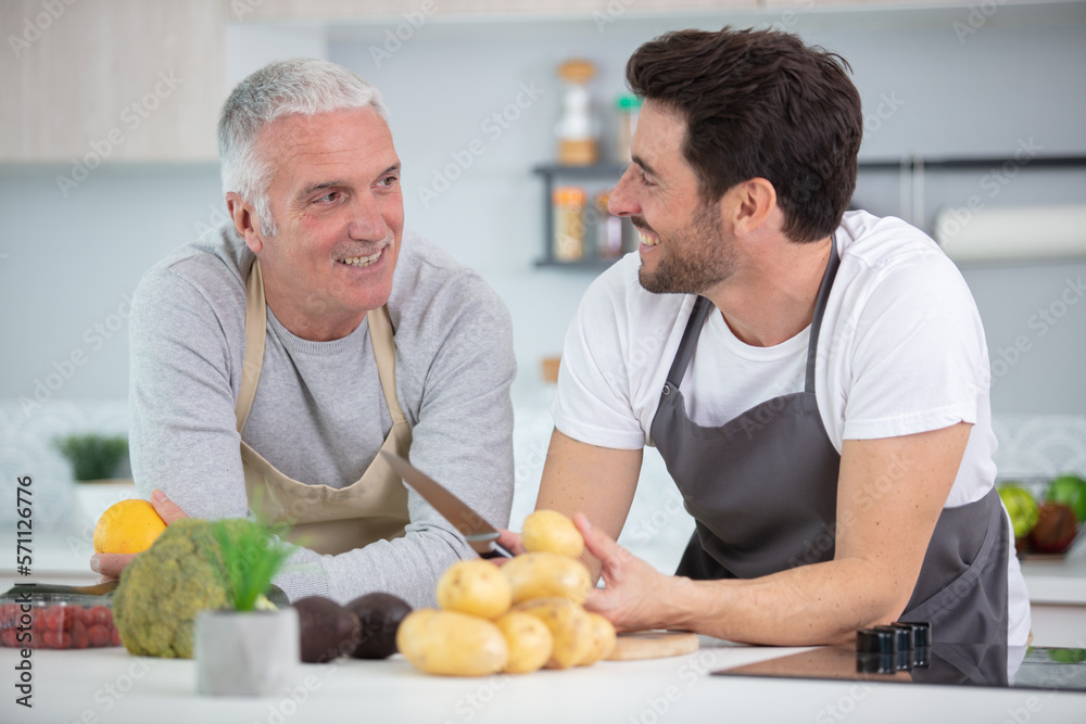 Fototapeta premium son helping father to prepare vegetable stew at kitchen