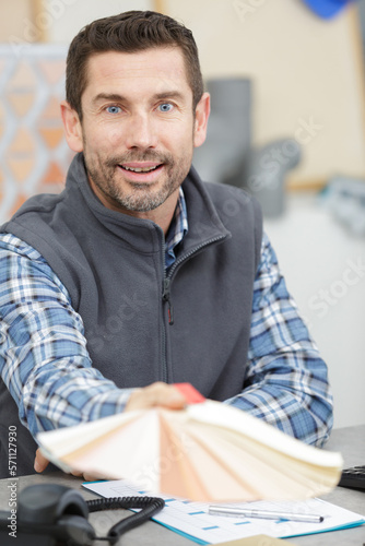 man showing colour swatches in his office