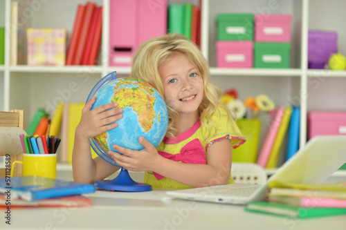 girl studying with a globe at the table