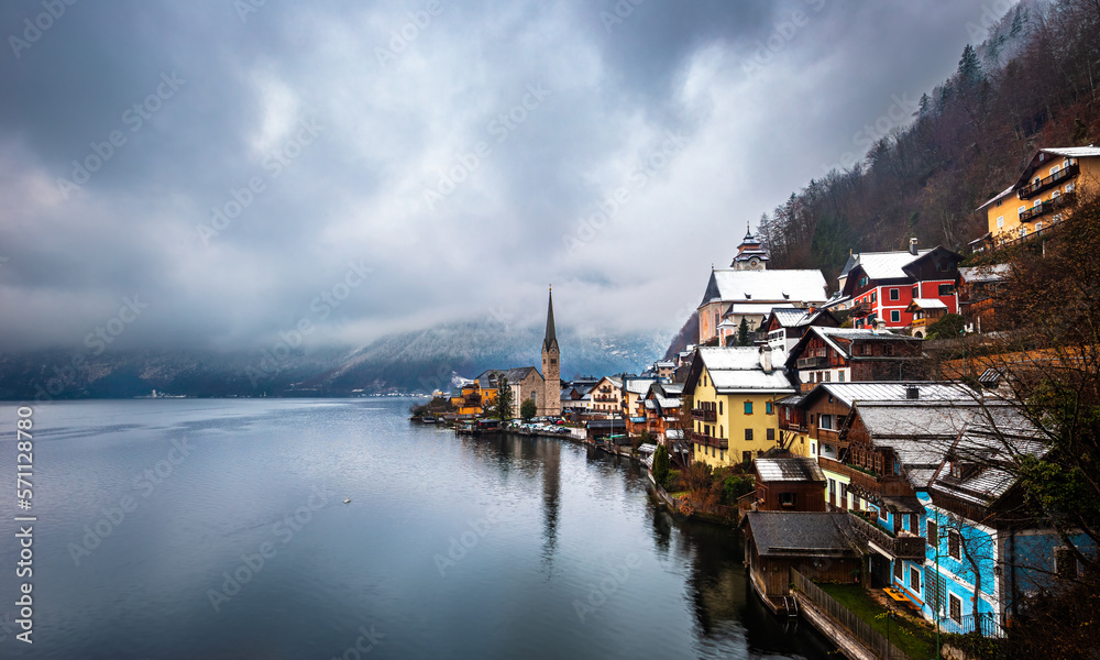 Hallstatt, Austria - Winter view of world famous Hallstatt, the Unesco protected lakeside town with Hallstatt Lutheran Church on a cold foggy day with snowy winter rooftops at Salzkammergut region