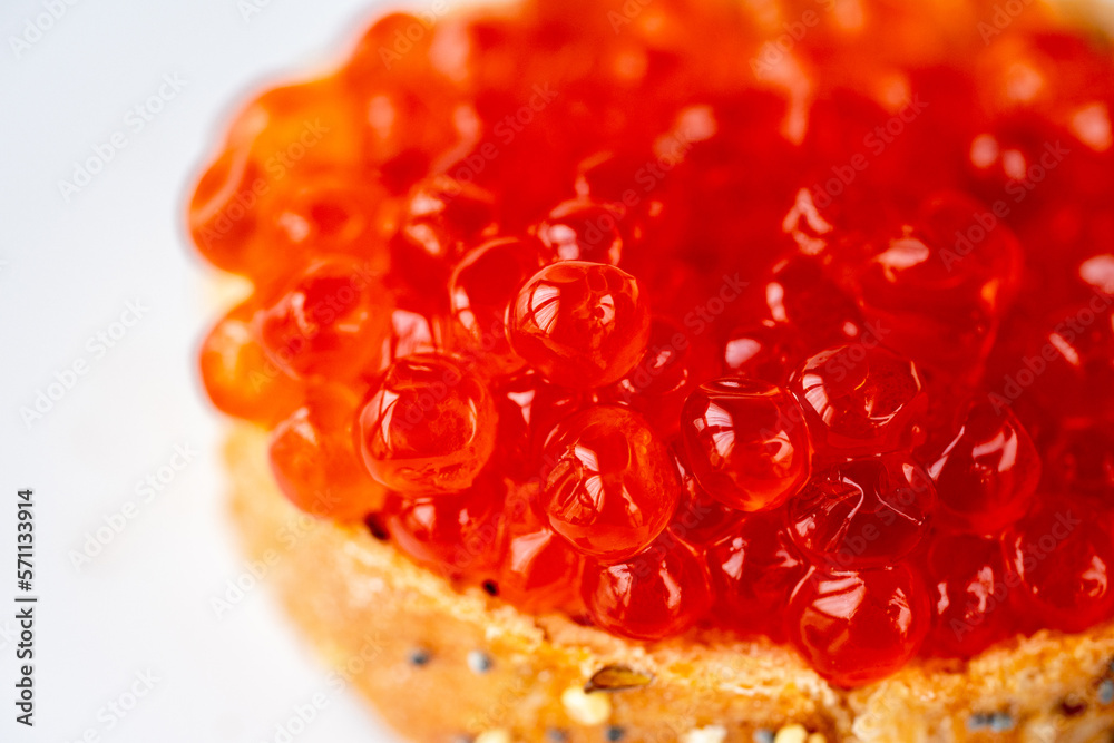 Red caviar sandwich. Red salmon caviar glows on a white background. Luxurious gourmet food. Raw seafood. Macro fish caviar.\nTexture of red caviar. Salmon caviar is grainy. Juicy fresh red caviar Red caviar sandwich. Red salmon caviar glows on a white background. Luxurious gourmet food. Raw seafood. Macro fish caviar.\nTexture of red caviar. Salmon caviar is grainy. Juicy fresh red caviar