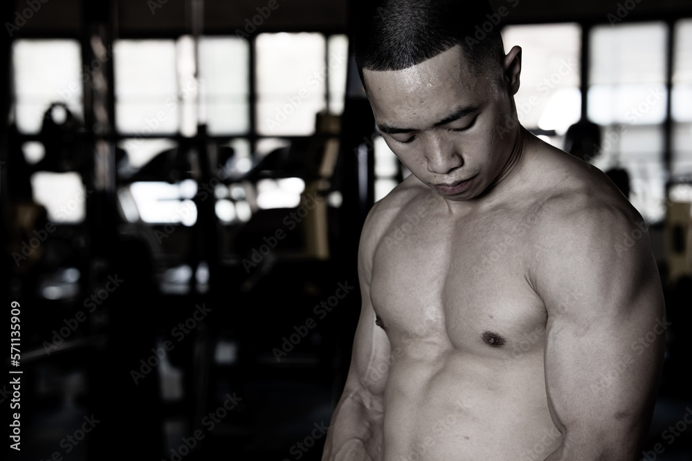 Sexy body of muscular young Asian man in gym. Concept of health care, exercise fitness, Strong muscle mass, body enhancement, fat reduction for men's health supplement product presentation. Sexy body of muscular young Asian man in gym. Concept of health care, exercise fitness, Strong muscle mass, body enhancement, fat reduction for men's health supplement product presentation.