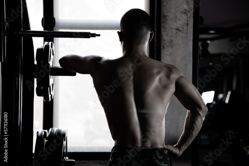 Sexy body of muscular young Asian man in gym. Concept of health care, exercise fitness, Strong muscle mass, body enhancement, fat reduction for men's health supplement product presentation. photo