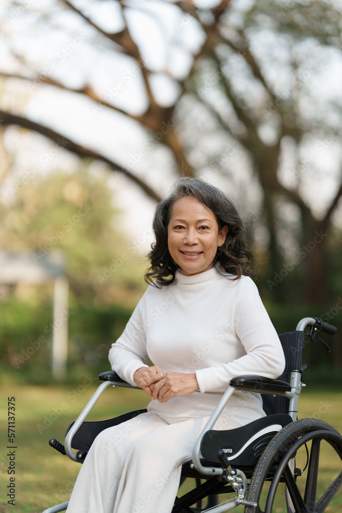 Obraz premium Happy senior asian women in wheelchair at home garden