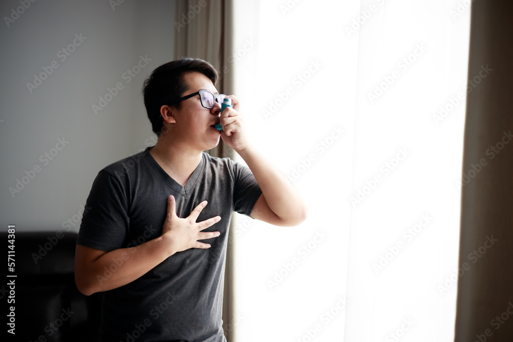 Sick Asian young man using nebulizer for asthma and respiratory diseases at home. Sick Asian young man using nebulizer for asthma and respiratory diseases at home.