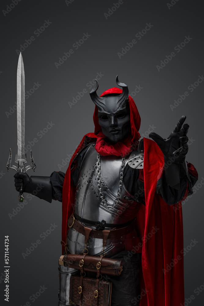 Fototapeta premium Shot of dark knight with plate armor and red robe armed with sword.