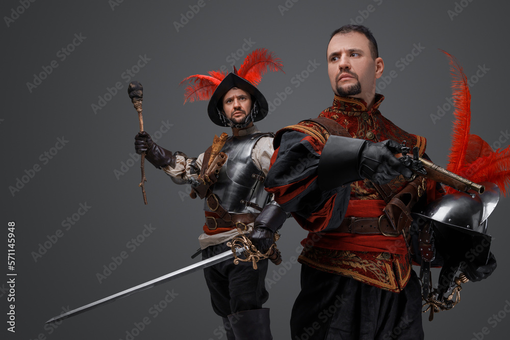 Portrait of isolated on gray background two conquistadors with pistol and torch. Portrait of isolated on gray background two conquistadors with pistol and torch.