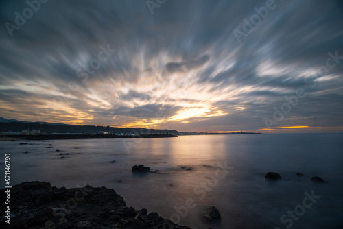 Dynamic fast moving clouds and red sunset. rocky coast. The view of the sea at dusk. Shimen District  New Taipei City  Taiwan