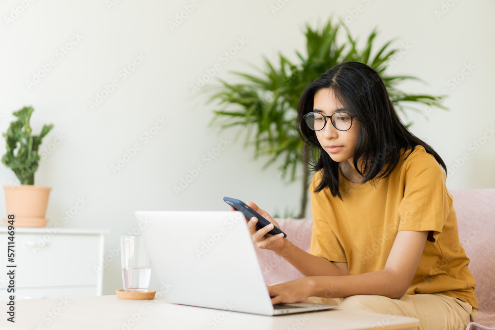 Asian woman typing work with laptop. Asia student using mobile phone Asian woman typing work with laptop. Asia student using mobile phone