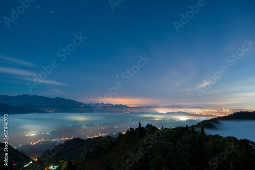 Night view of city lights in the valley. Spectacular cloud waterfall in the sky. The sea of clouds landscape. Dahu Township  Miaoli County  Taiwan