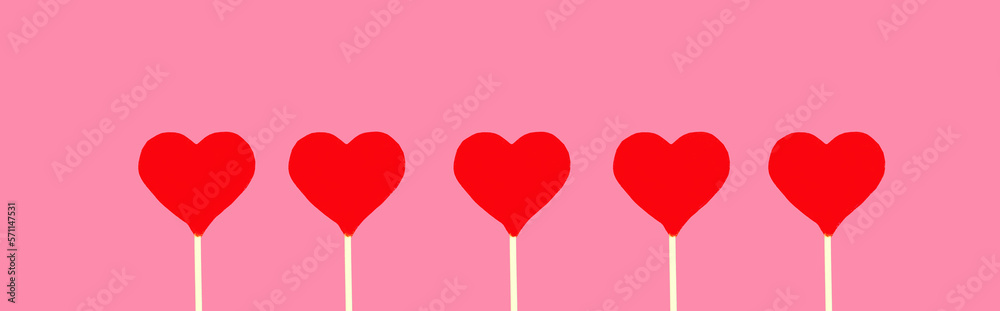Close up sweet red heart shaped lollipop on pink background
